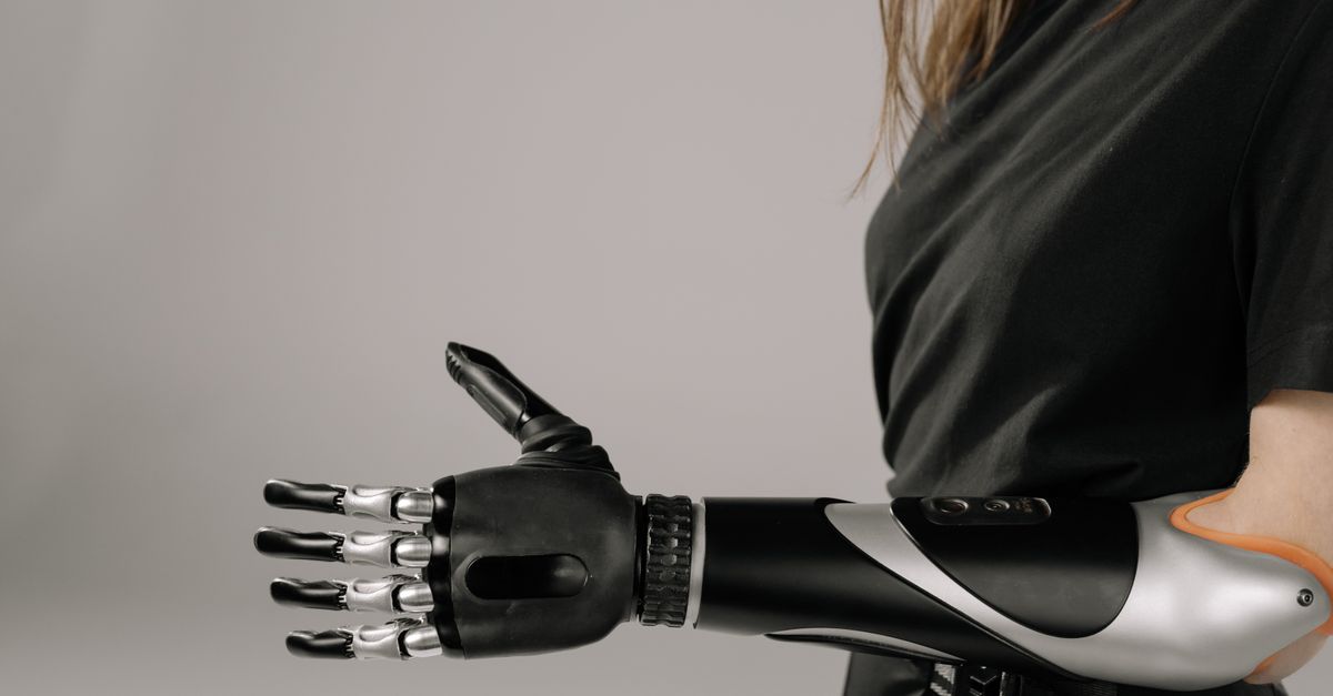Close-up of a woman wearing a sleek, modern prosthetic arm. Studio shot emphasizes technology and innovation.